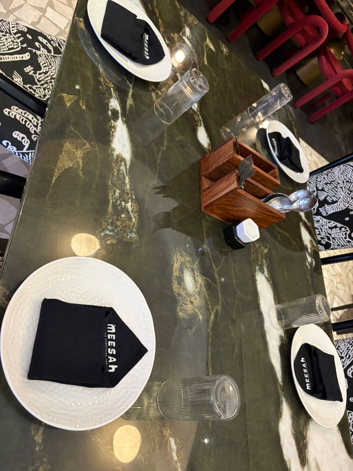 Meesah dining table with black napkins and printed tiger chairs
