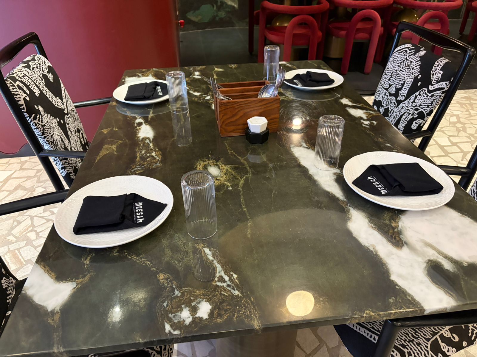 Meesah restaurant table setup with red bar seating in background