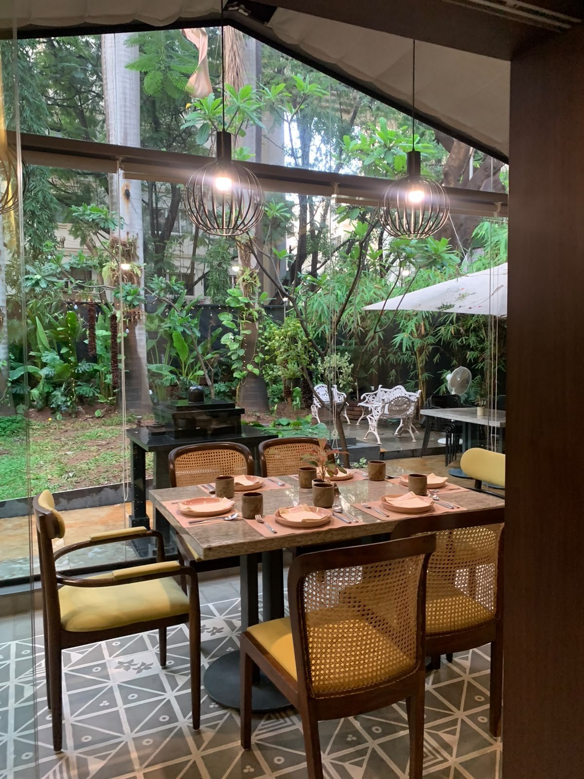 Garden-view café with cane chairs and napkin setup