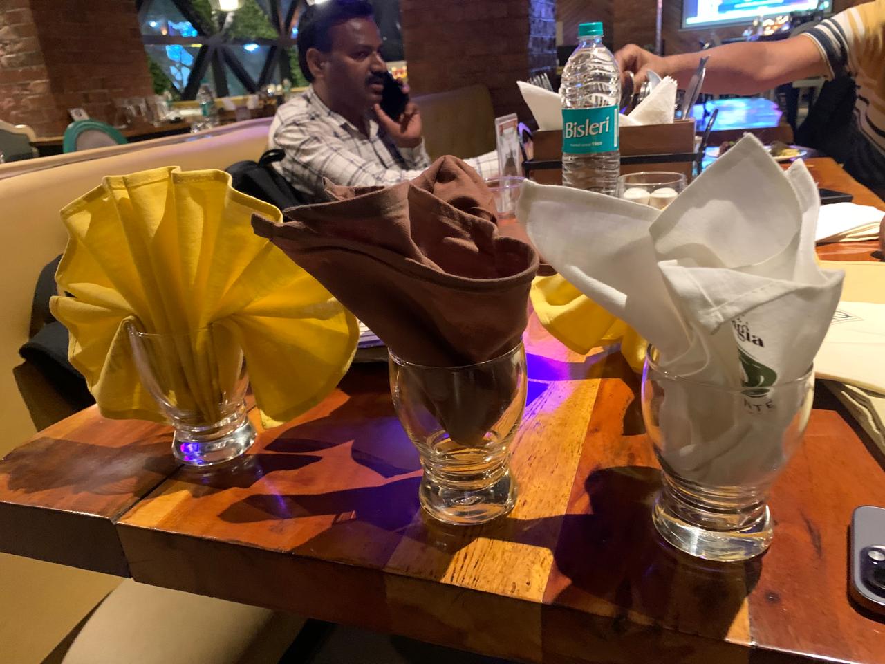 Trio of coloured napkin folds — yellow, brown and white