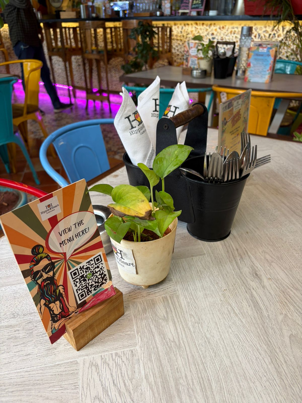 Hippie @ Heart branded napkins with menu QR and plant on café table