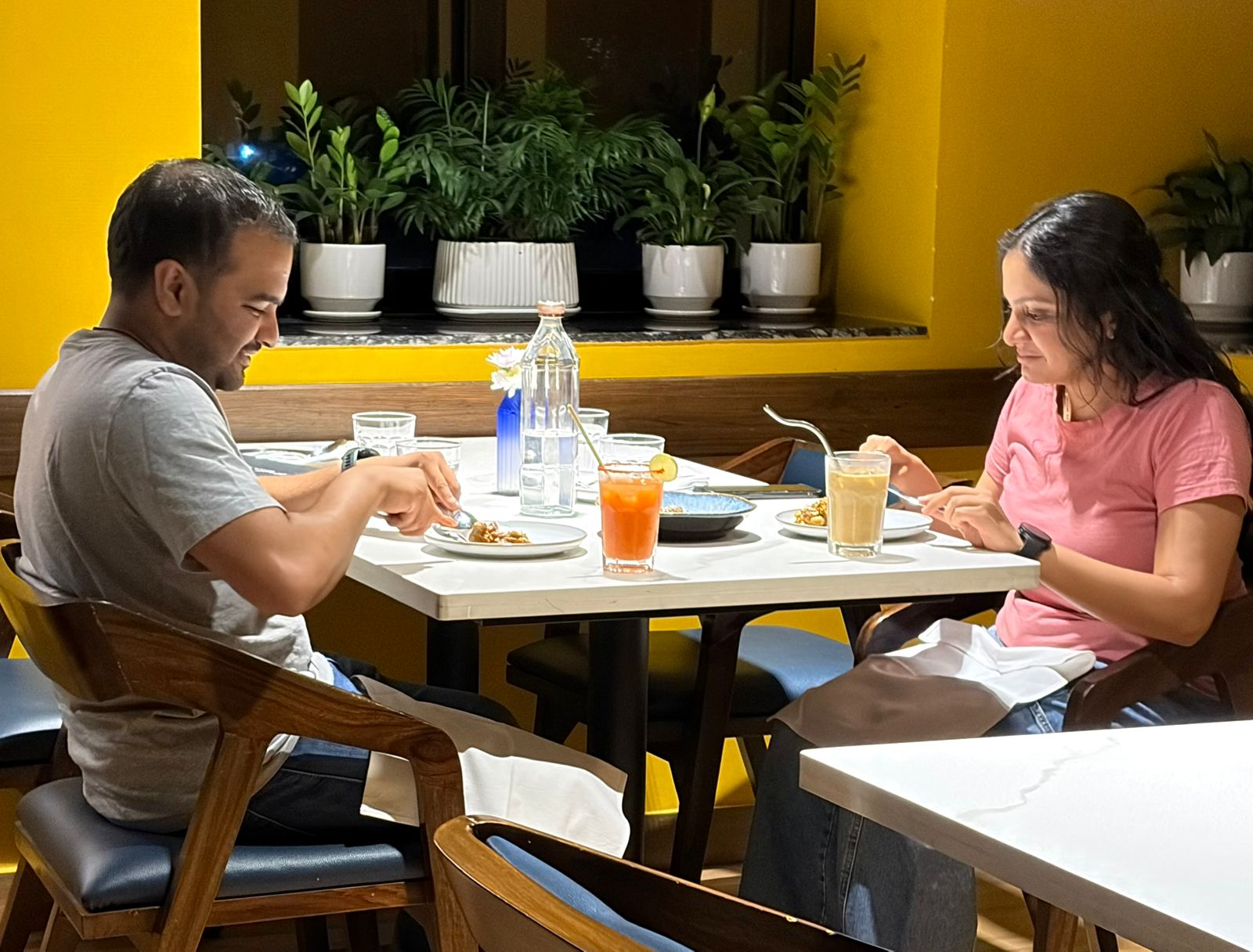Guests enjoying a meal at a yellow-accented fine dining restaurant