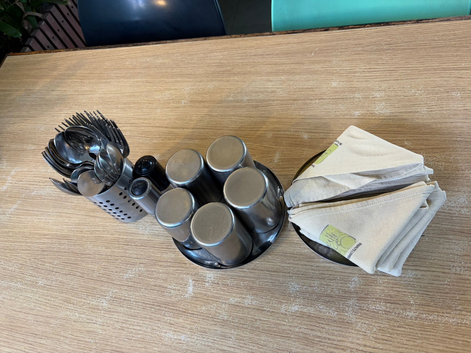 Branded cream cloth napkins with cutlery caddy on wooden table