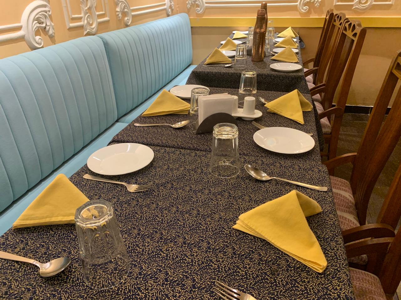 Long banquette table with yellow napkin folds
