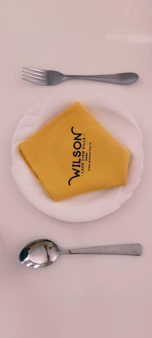 Wilson branded yellow napkin on plated setting